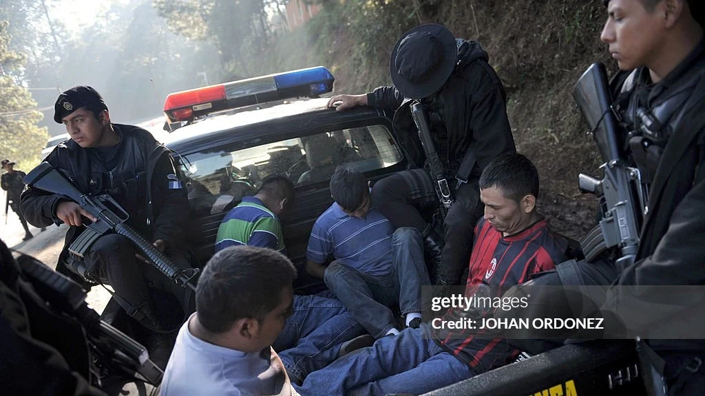 File photo: Guatemalan police load onto a pickup four suspects allegedly...